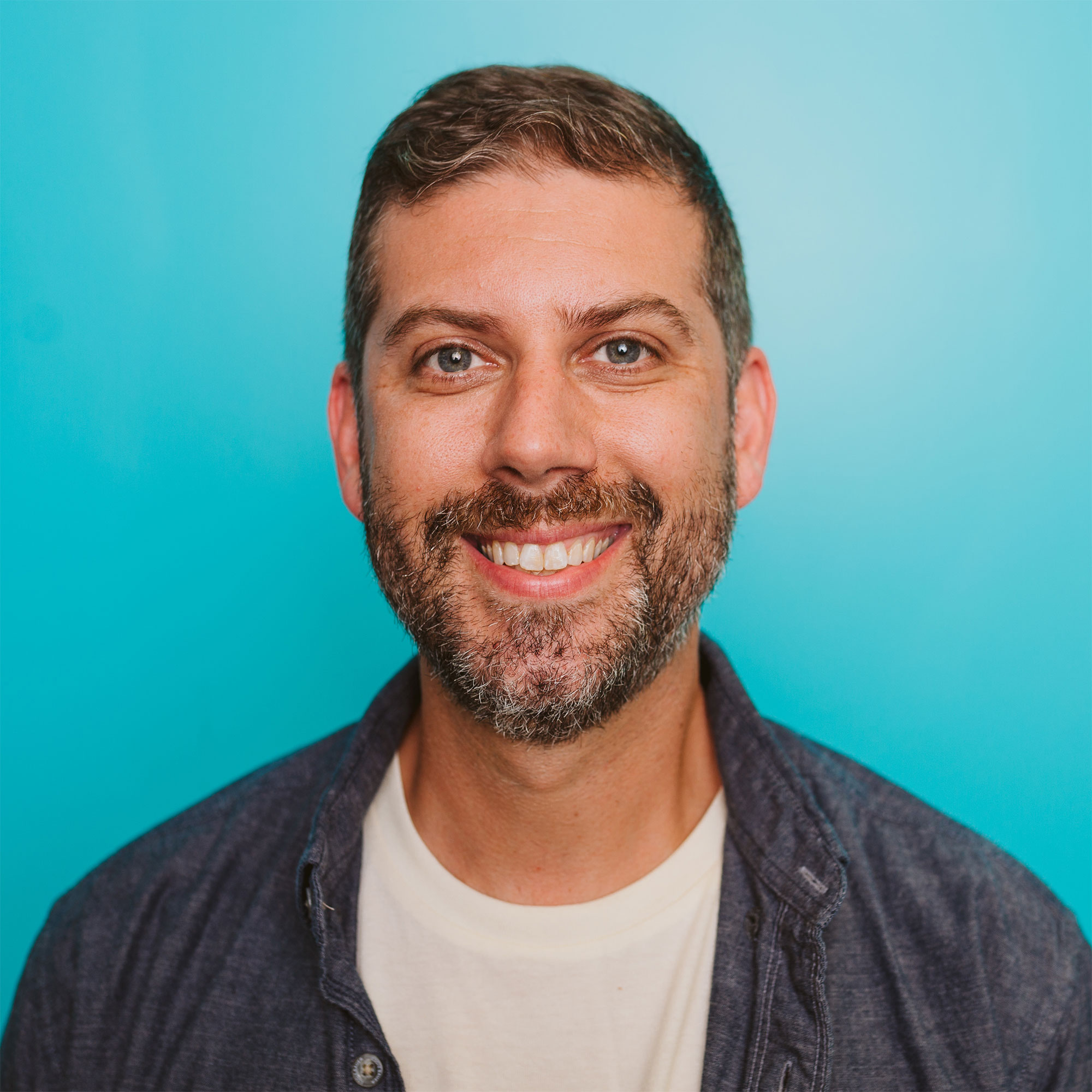 Andrew Kerr smiling against a blue background
